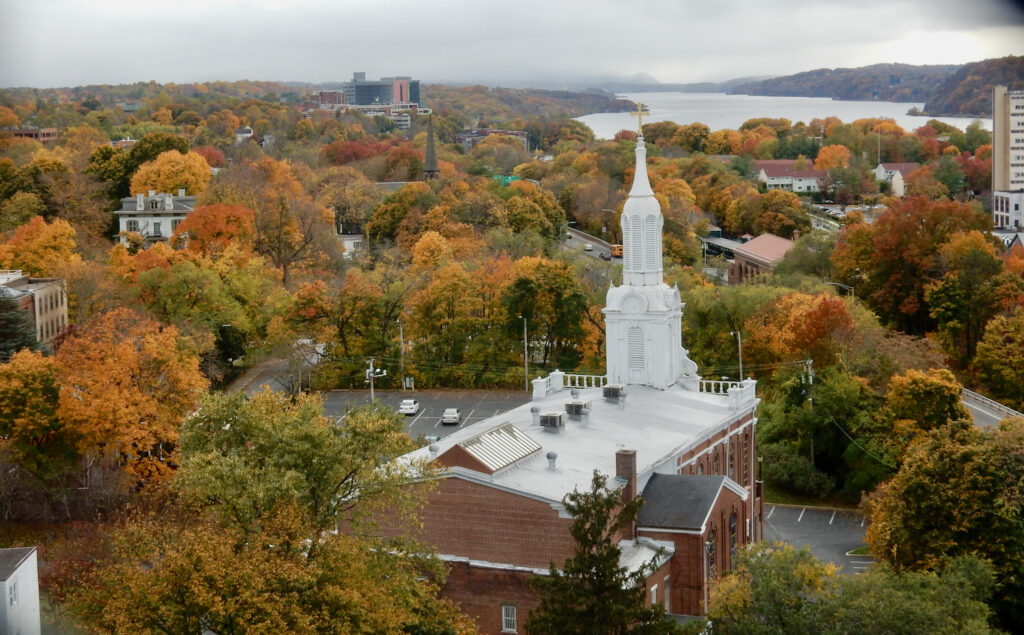 New York Hudson River town in autumn with white steeple church.